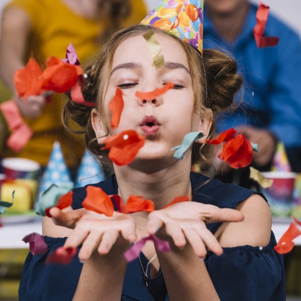 retrato-adolescente-que-sopla-confeti-su-cumpleanos
